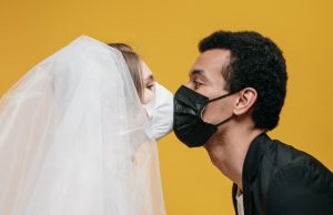 ¿Cuáles son las recomendaciones oficiales para el sexo seguro en la era del COVID-19? Dos personas con mascarillas faciales besándose